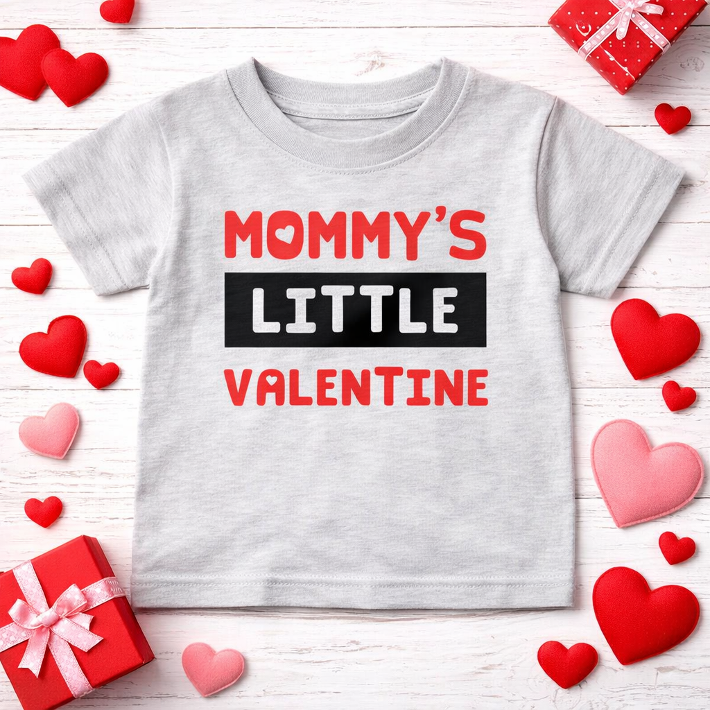 Gray t-shirt with 'Mommy's Little Valentine' text on a wooden surface with heart decorations.